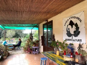 Terraza de la finca con el cartel de Finca S'Esquirol Permacultura