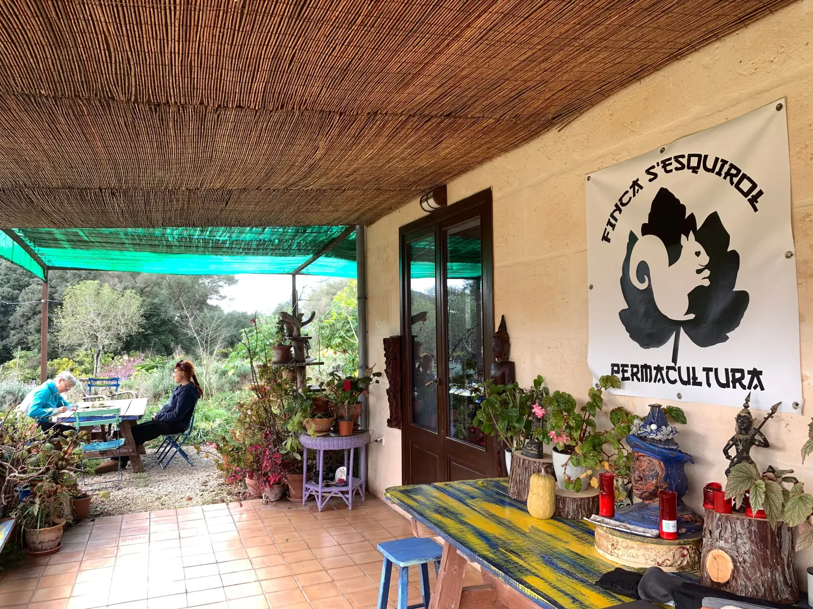 Terraza de la finca con el cartel de Finca S'Esquirol Permacultura