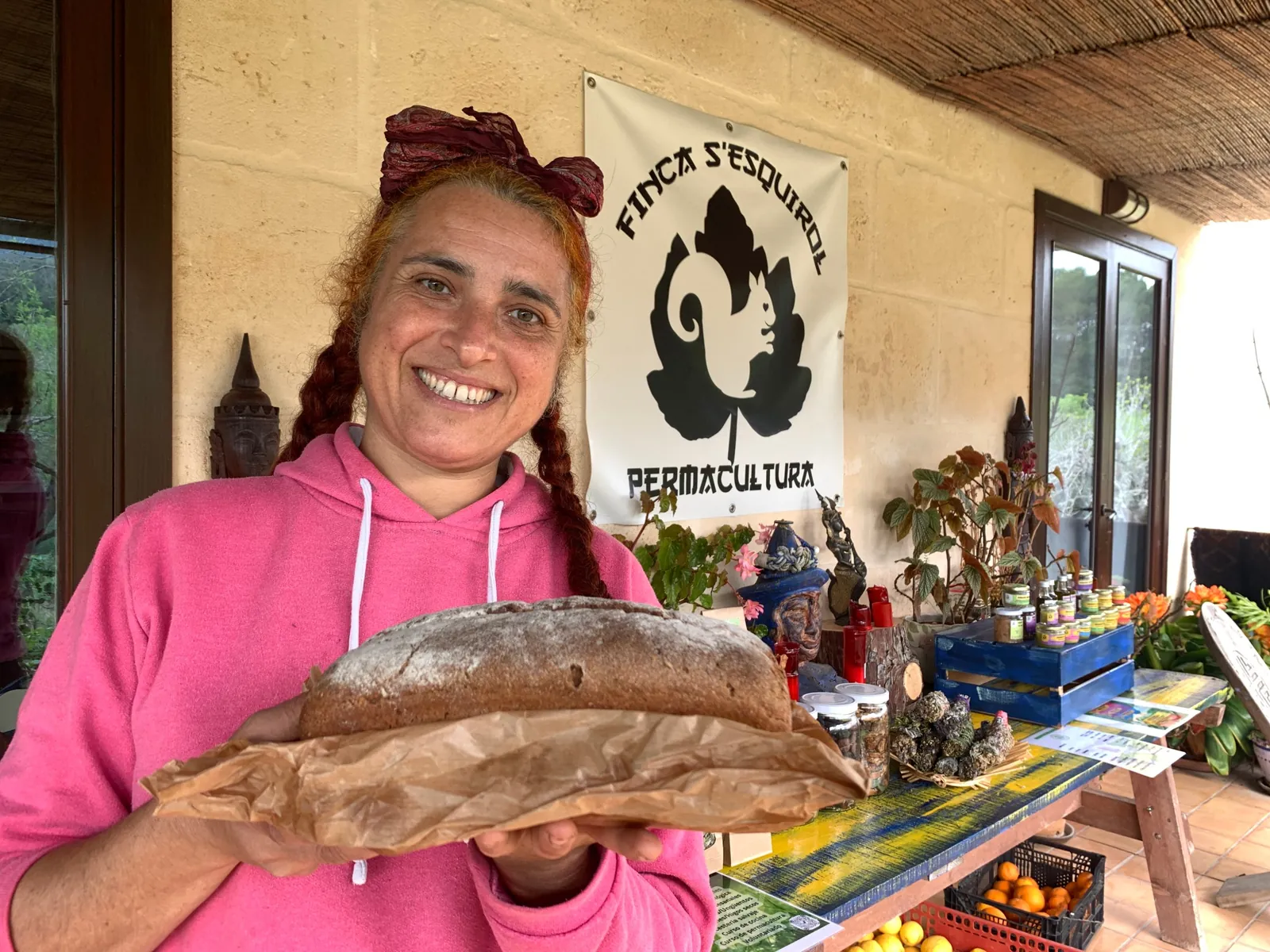 Mujer sonriente mostrando una hogaza de pan